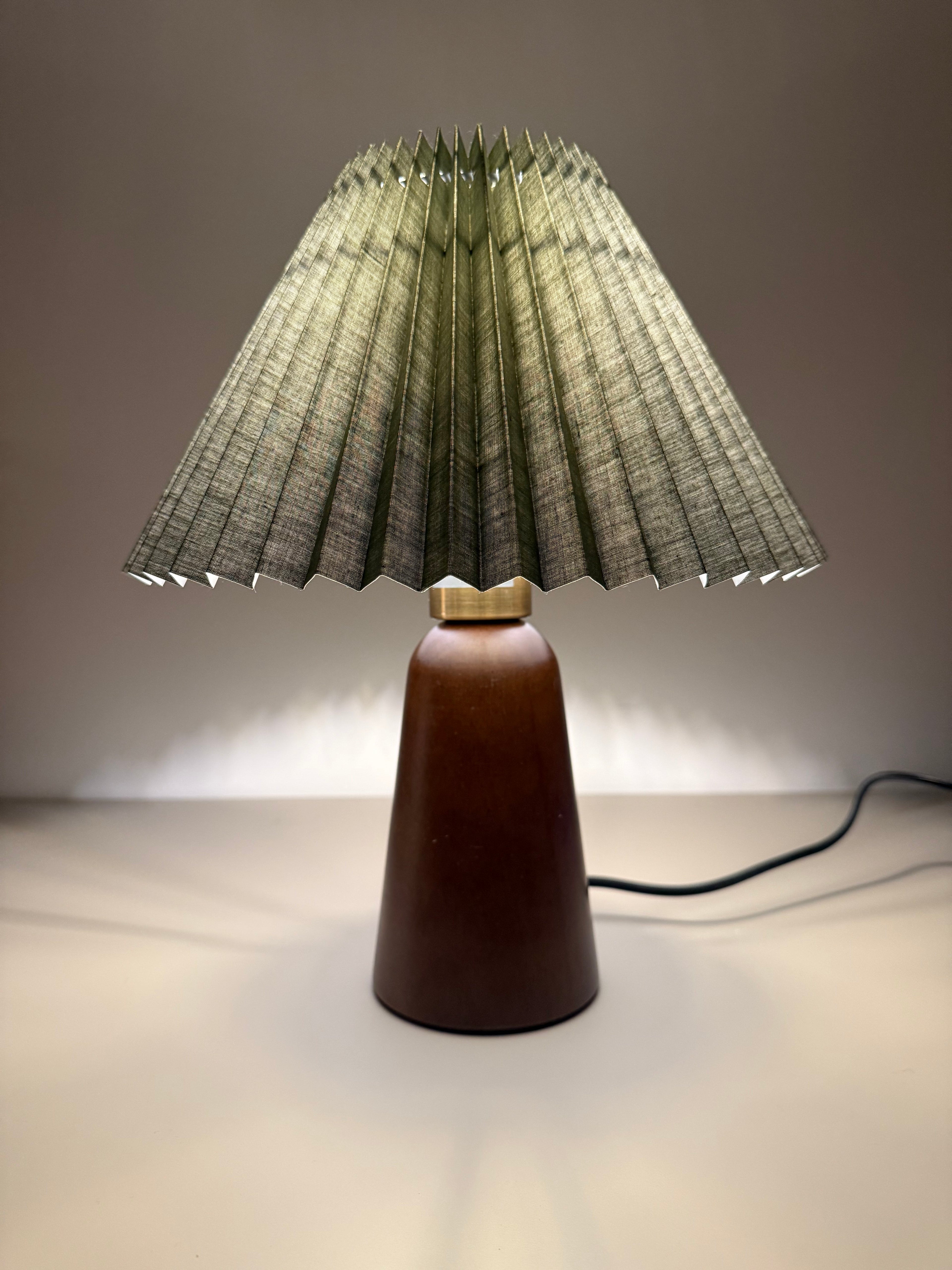 „Olivia Verde“ Tischlampe – Gefalteter Stoffschirm in Olivgrün | Design-Leuchte mit Holzoptik-Sockel