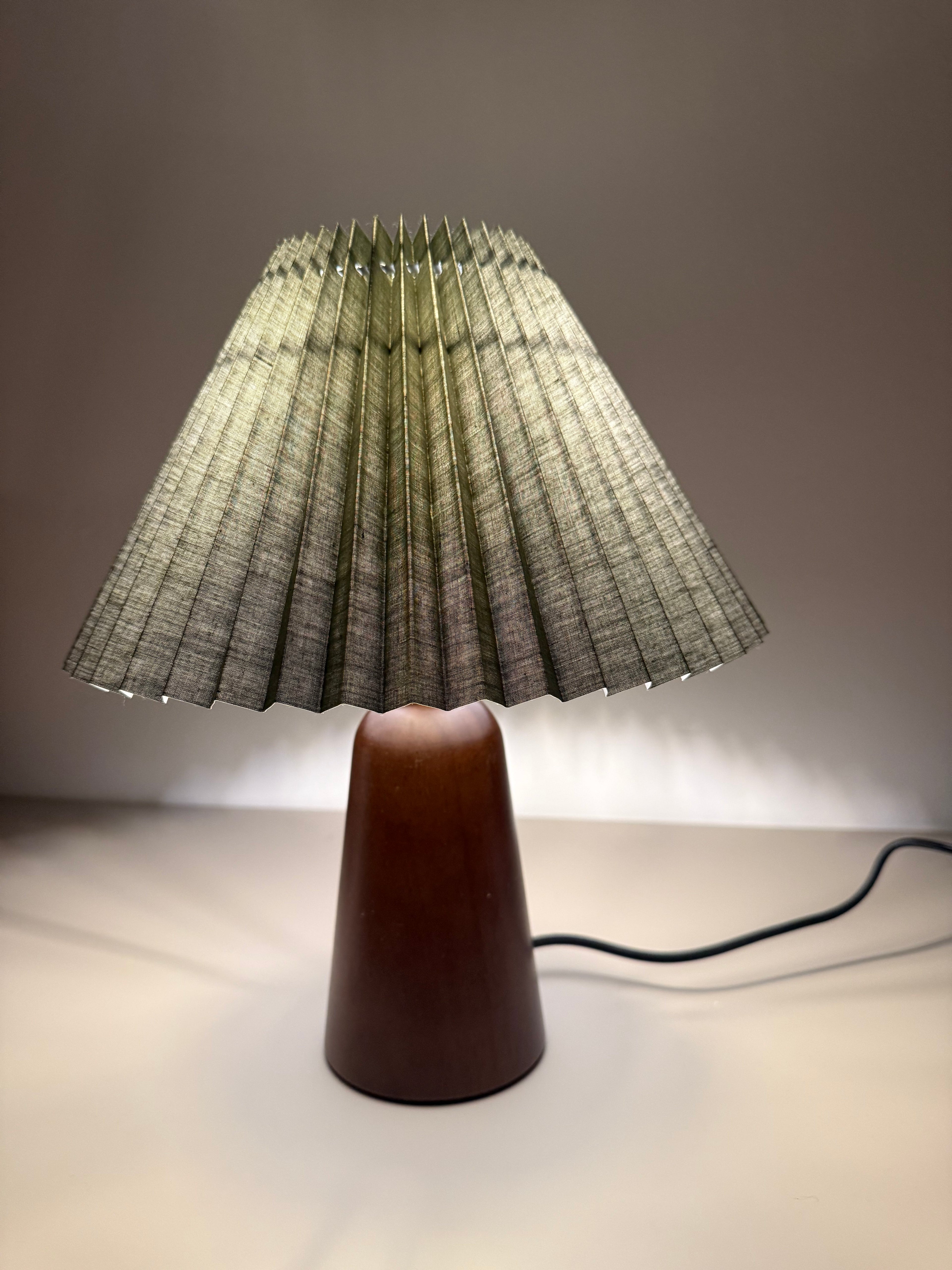 „Olivia Verde“ Tischlampe – Gefalteter Stoffschirm in Olivgrün | Design-Leuchte mit Holzoptik-Sockel